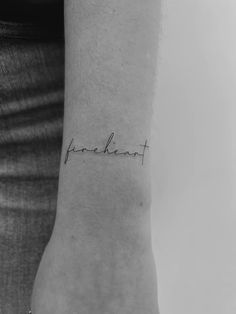 a person with a small tattoo on their wrist that says, freakent in cursive writing