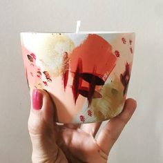 a hand holding a cup with some paint on it