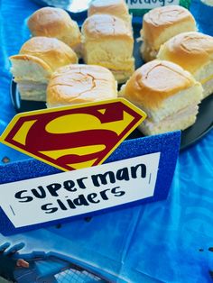 there are many small sandwiches on the table with a sign that says superman sliders