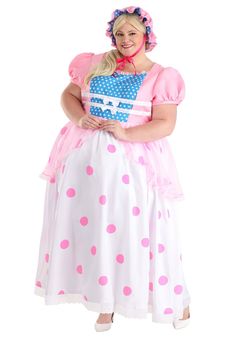 a woman in a pink and white polka dot dress is standing with her hands on her hips