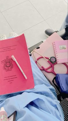 a pink folder with a stethoscope on top of it