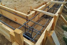 an unfinished wooden structure is being built in the sand