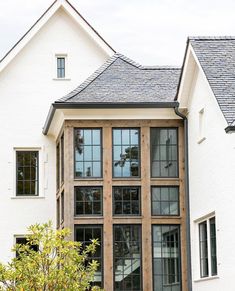 a white house with black windows and brown shutters