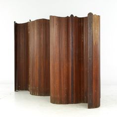 three tall wooden screens sitting on top of a white floor