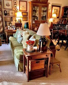 a living room filled with furniture and lots of framed pictures on the wall above it