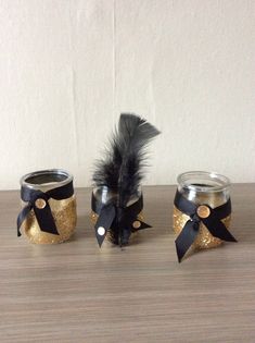 three small jars with black and gold decorations