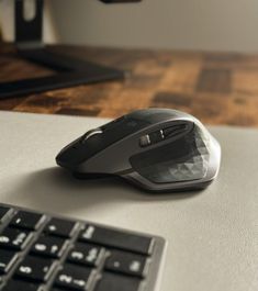 a computer mouse sitting on top of a desk next to a keyboard and mouse pad