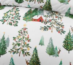 a bed with christmas trees and deers on it