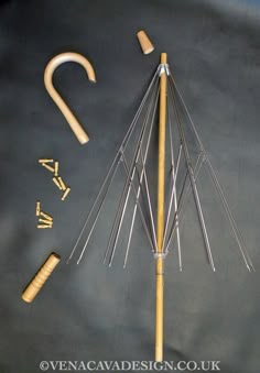 a wooden stick and some metal items on a black surface with the word whisk written in gold