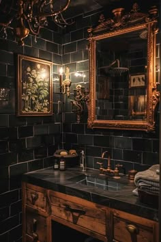 a bathroom with black tiles and gold fixtures, including a vanity mirror above the sink