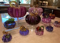 there are many glass pumpkins sitting on the counter top in front of each other