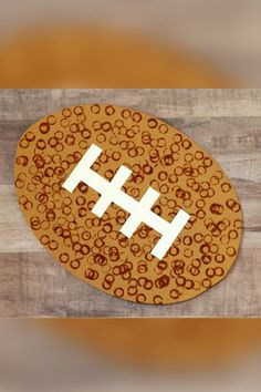 an image of a football on wood with circles around it and the letter h in white