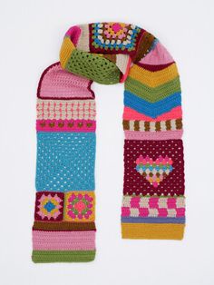 a multicolored knitted scarf with flowers and hearts on the front, sitting against a white background