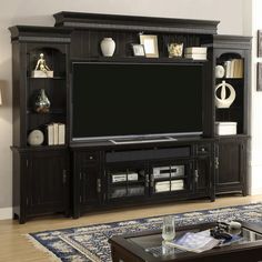 a living room with an entertainment center and coffee table