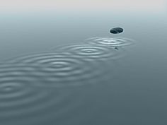 two rocks in the middle of water with ripples on it and one rock sticking out of the water's surface