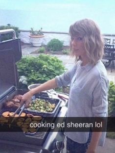 a woman standing next to an open grill on top of a patio with food in it