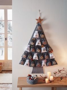 a christmas tree made out of fabric on top of a wooden table next to a window