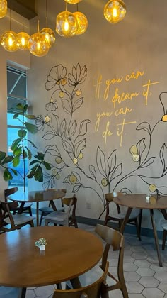 an empty restaurant with tables and chairs in front of a wall mural that says if you can dream of you can do it