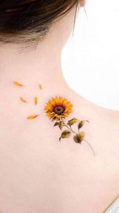 a sunflower tattoo on the back of a woman's neck