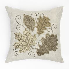 an embroidered pillow with leaves on it