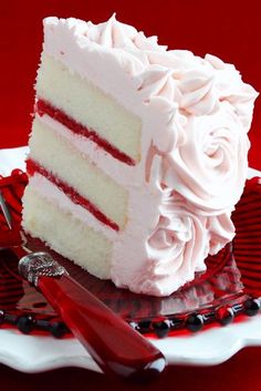 a piece of cake with white frosting and red stripes on it sitting on a plate