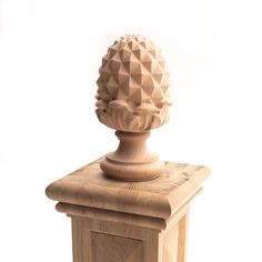 a wooden object with a carved pineapple on it's top and bottom part