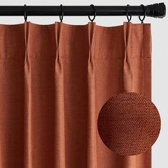 an orange curtain with a round hole in the middle and a black rod attached to it