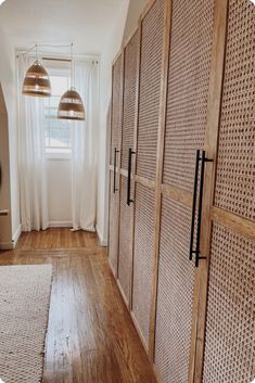 a room that has some wooden doors and lights in it, along with a rug on the floor