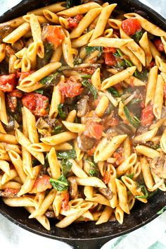 a skillet filled with pasta and vegetables