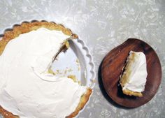 a piece of pie sitting on top of a table next to a wooden plate with a slice missing