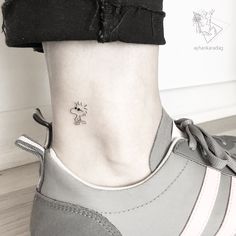 a woman's foot with a small tattoo on the side of her ankle,