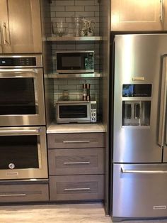 a stainless steel refrigerator freezer sitting next to an oven and microwave in a kitchen