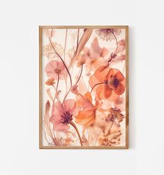 an orange and pink floral painting hanging on a wall