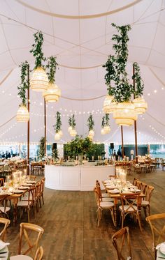 the inside of a tent with tables and chairs set up for an outdoor wedding reception