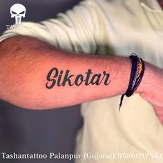 a man with a tattoo on his arm that says skotar in black ink