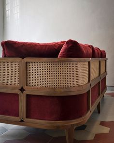 a red couch sitting on top of a wooden frame