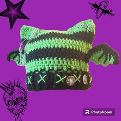 a green and black crocheted bag with a skull on the front, stars in the background