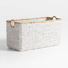 a white basket with gold handles on the bottom and handle is sitting in front of a white background