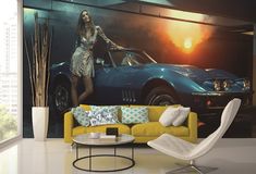 a woman standing next to a blue sports car in a living room with large windows