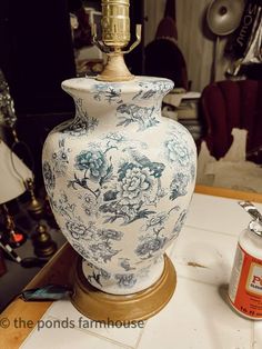 a blue and white vase sitting on top of a table next to a paint can