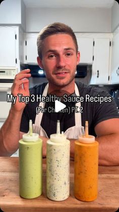 a man is holding three sauces in front of him