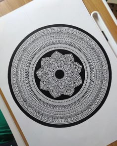 a black and white drawing of a flower in the middle of a circle on paper