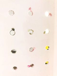 a white wall with many different colored circles and holes on it's side,