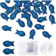 small blue plastic fish next to a package of clear plastic buttons and thread spools