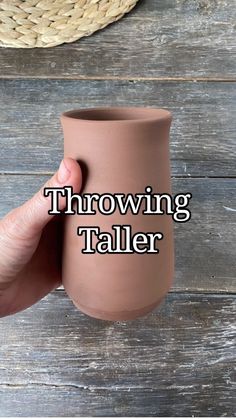 a hand holding a brown vase with the words throwing taller on it