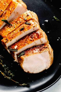 pork chops on a black plate with herbs