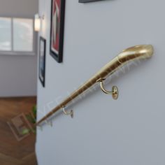 an umbrella is hanging on the side of a white wall in a room with wood flooring