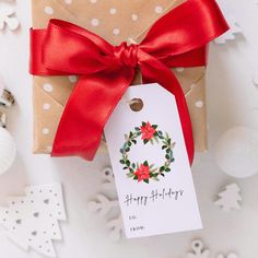 a gift wrapped in brown paper with a red ribbon and a tag that says happy holidays