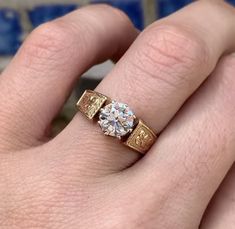 a close up of a person's hand with a diamond ring on their finger