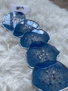 four blue glass dishes sitting on top of a white furnishing covered floor next to each other